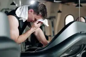 Tired man wiping sweat from his brow after a workout